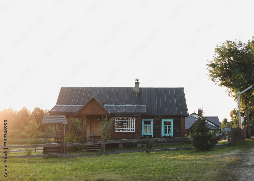 old wooden house in village. Farmhouse in Belarus. View of rustic ethnic house on sunset. rural landscape old wooden house in village. Farmhouse in Belarus. View of rustic ethnic house on sunset. rural landscape