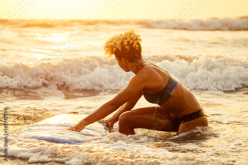 Photography african american surfer girl in water enjoying sunset
