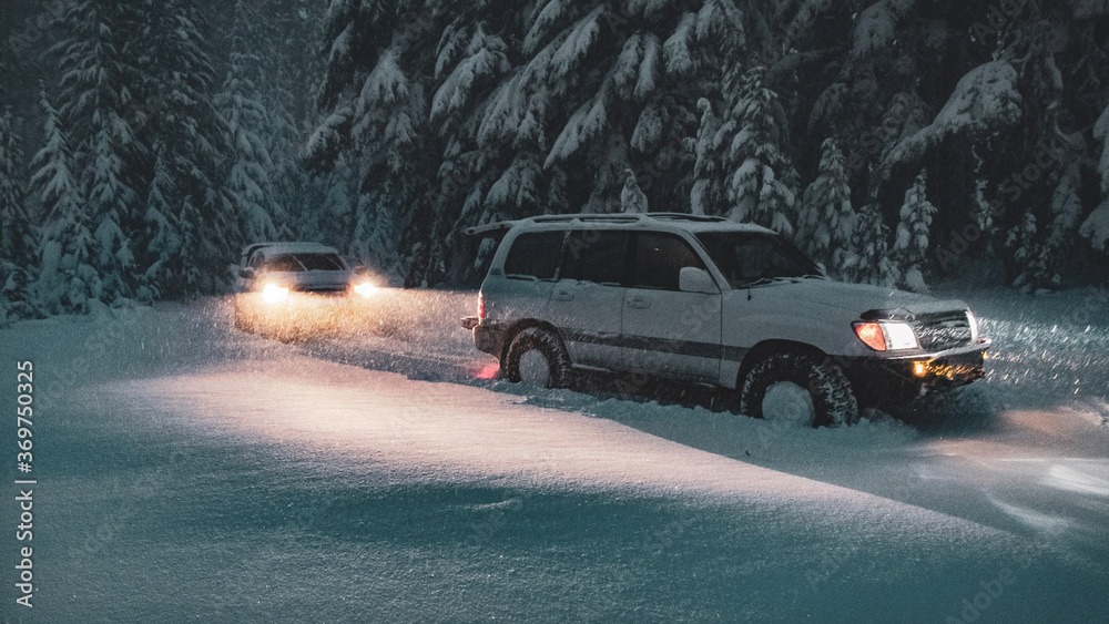 Offroad SUVs driving in the snow at night in Central Oregon