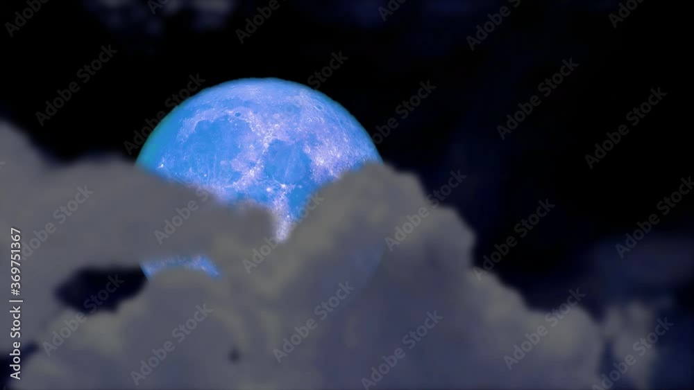 full blue moon back on night sky and blur cloud moving pass full blue moon back on night sky and blur cloud moving pass