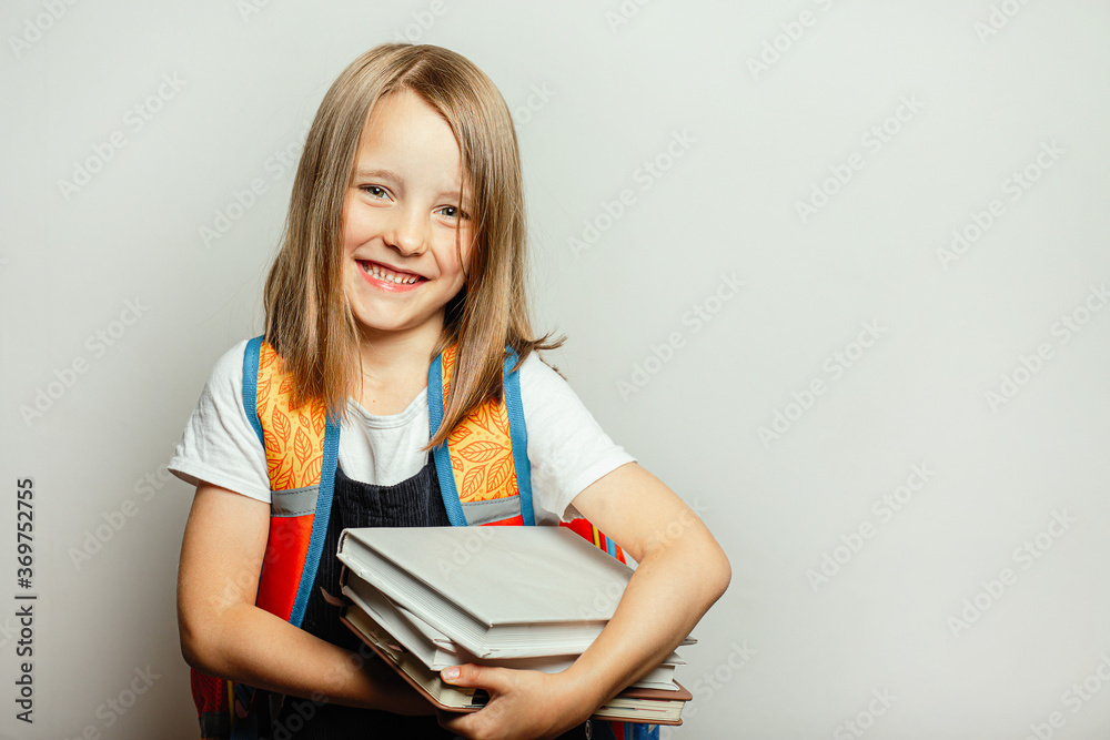 Child with textbooks and knapsack preparing for school, concept of the beginning of the study period, back to school Child with textbooks and knapsack preparing for school, concept of the beginning of the study period, back to school