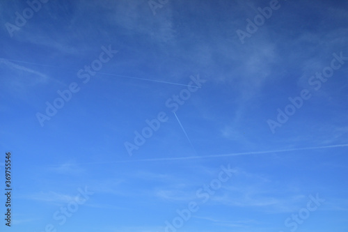Clouds and traces of airplanes in the blue sky.