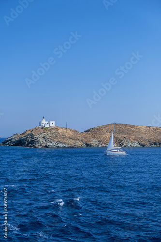 Greece, Kea Tzia island. Seascape with lighthouse and a sailboat, clear blue sky © Rawf8