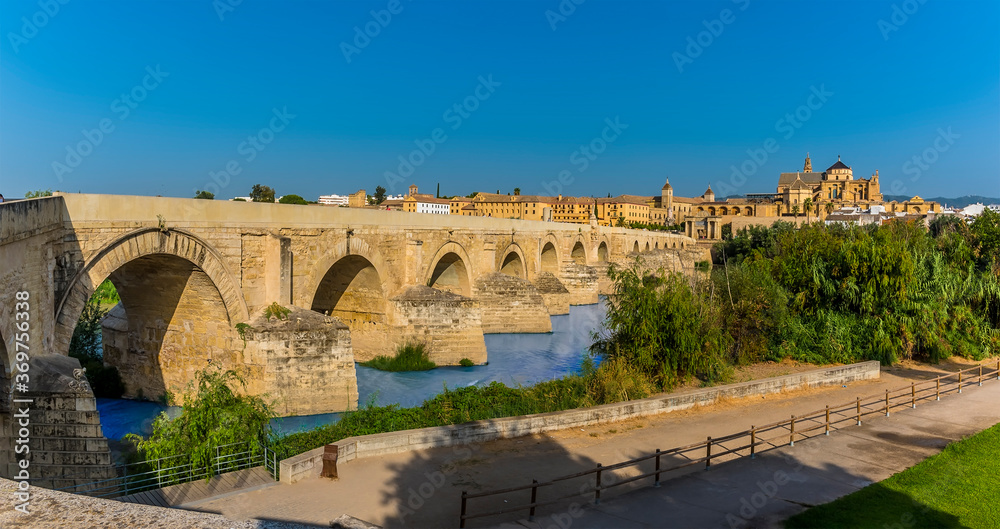A panorama along the Roman bridge leading into the ancient city of Cordoba, Spain in the summertime