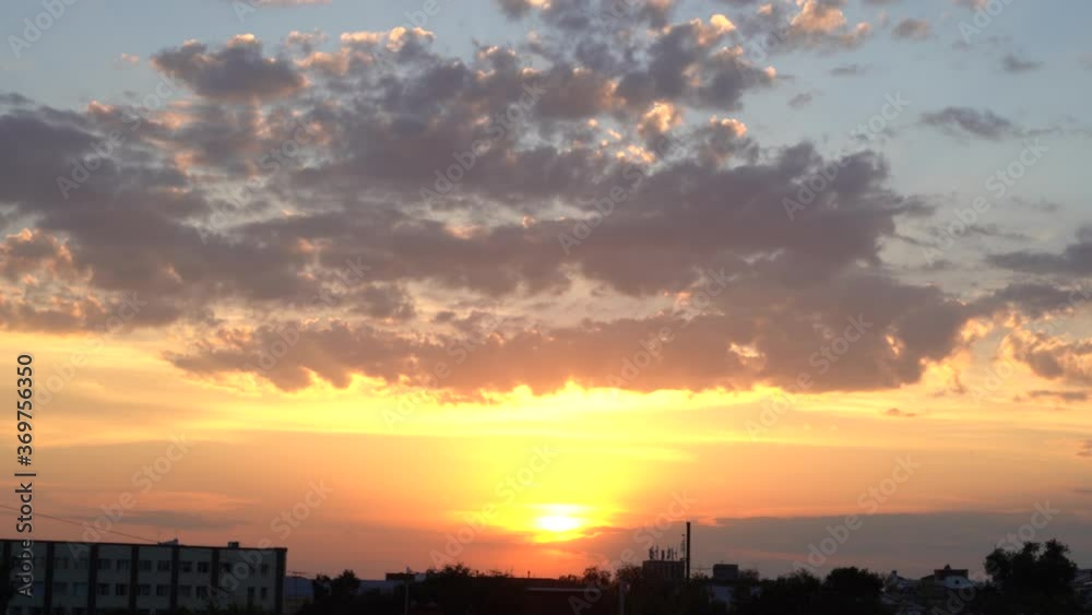 Beautiful evening blue sky at sunset with flaming bright light clouds. A warm summer evening at sunset. Bright sunset. Beautiful evening blue sky at sunset with flaming bright light clouds. A warm summer evening at sunset. Bright sunset.