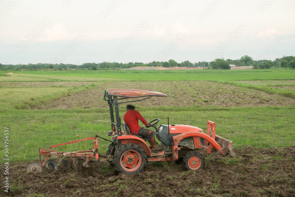 Tractor working plows a field on the farm for planting. Tractor working plows a field on the farm for planting.