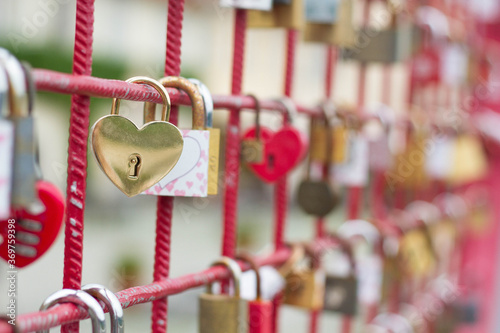 Love locks on the bridge with heart shaped gold lock in the front. 