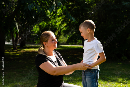 Mom and son holds hands in nature, park, outdoor. Trust and love in family. Summer family walk