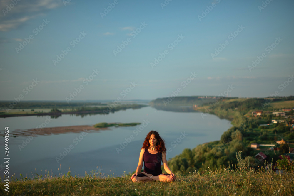 Yoga practice and meditation in nature in sunrise. Woman practicing near big river Kama. Yoga practice and meditation in nature in sunrise. Woman practicing near big river Kama.