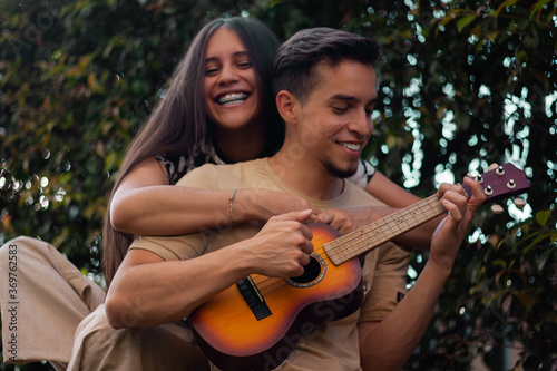 young couple plays ukulele in summer days