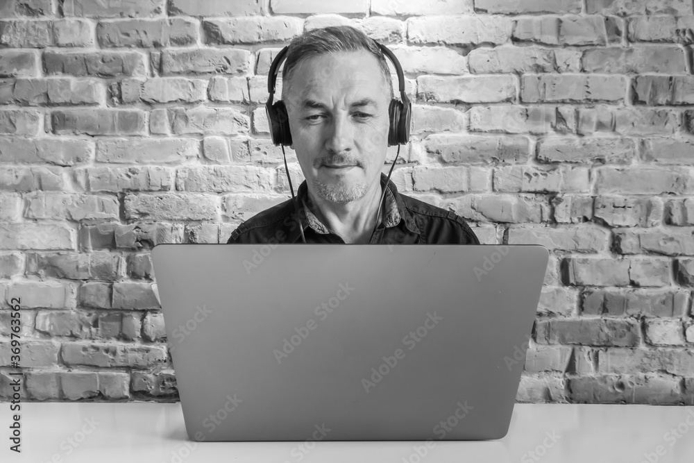 Middle-aged man with headphones and laptop Middle-aged man with headphones and laptop