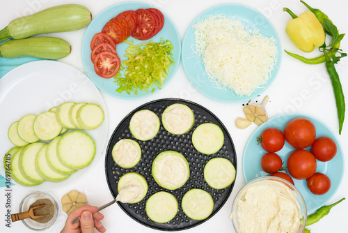 step by step recipe and ingredients for cooking homemade zucchini mini portioned pizza with mozzarella and tomatoes  pepper and garlic. top view on a light background.