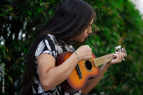 young woman plays acoustic instrument in summer