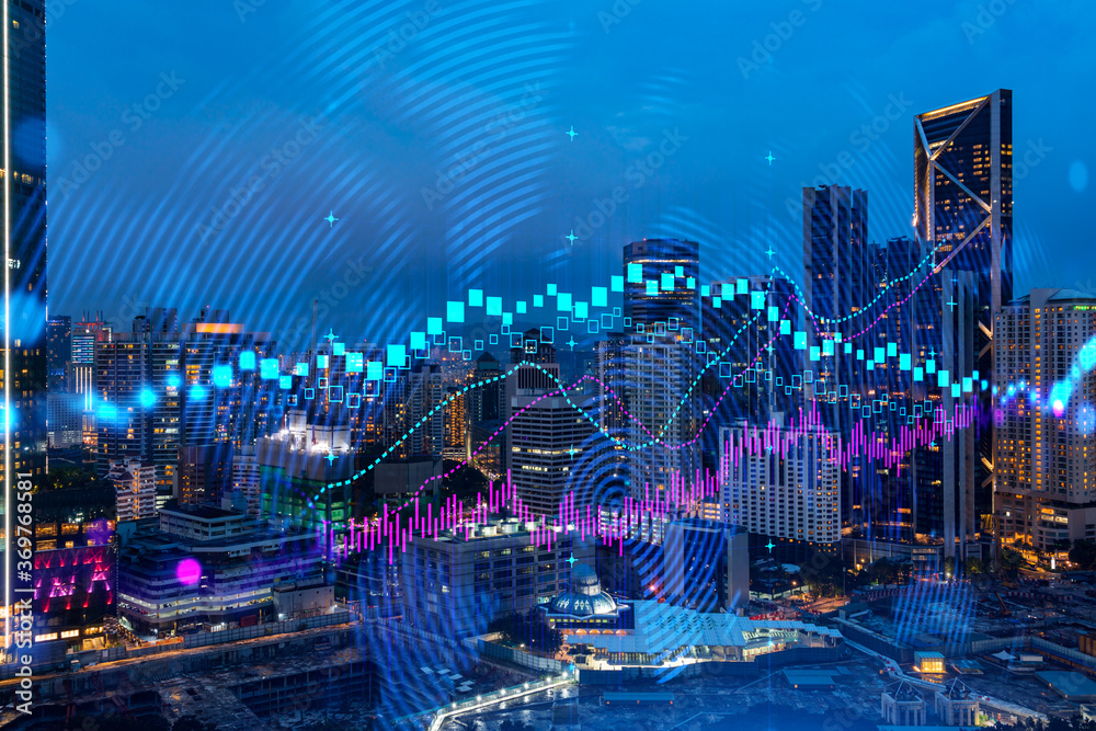 FOREX graph hologram, aerial night panoramic cityscape of Kuala Lumpur. KL is the developed location for stock market researchers in Malaysia, Asia. The concept of fundamental analysis.