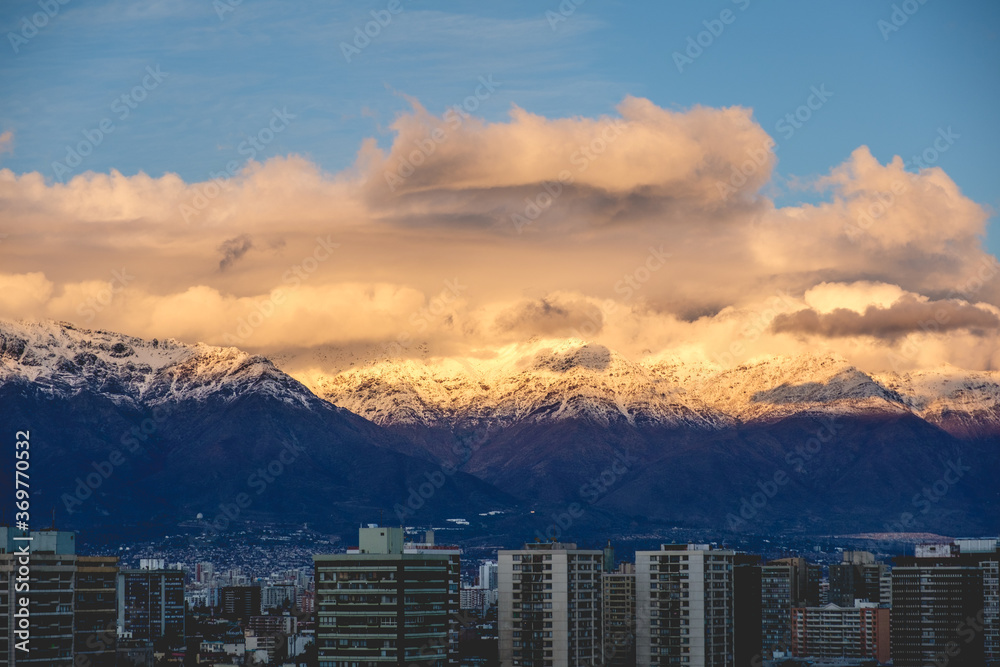 Amazing clouds and blue sky over Santiago and The Andes Mountains with a golden sunlight, Chile