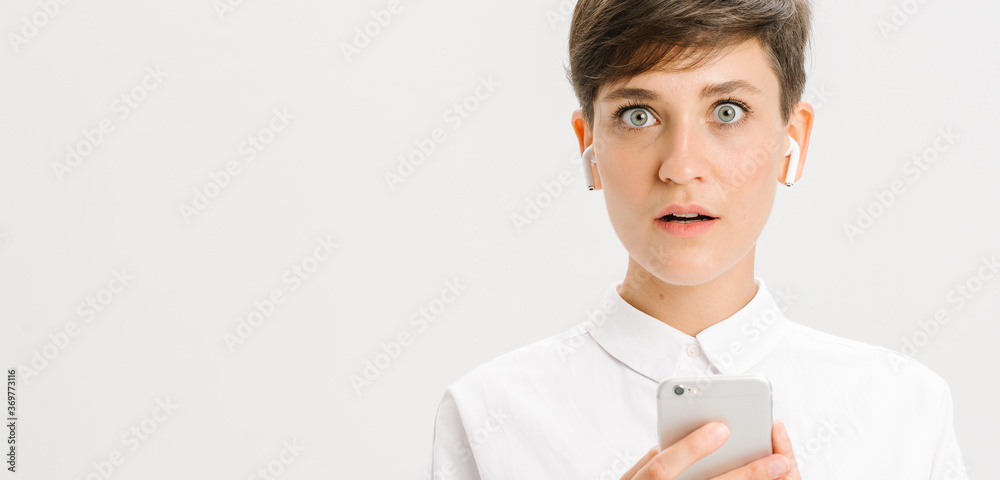 businesswoman uses wireless headphones for a video call. white background in studio. online business meeting concept businesswoman uses wireless headphones for a video call. white background in studio. online business meeting concept