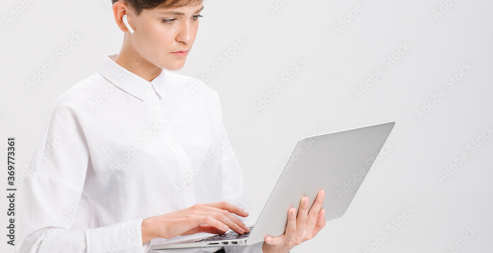 a young woman uses wireless headphones for a video call. white background in studio. online business meeting concept a young woman uses wireless headphones for a video call. white background in studio. online business meeting concept