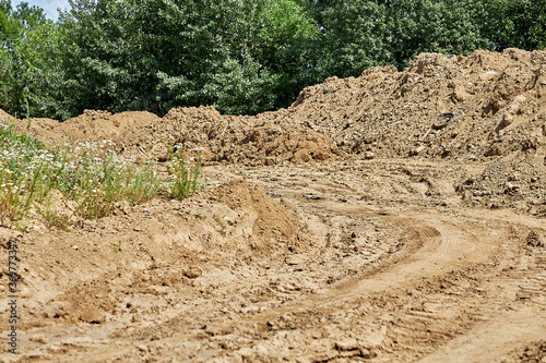 Road with traces of construction equipment of a pile of earth