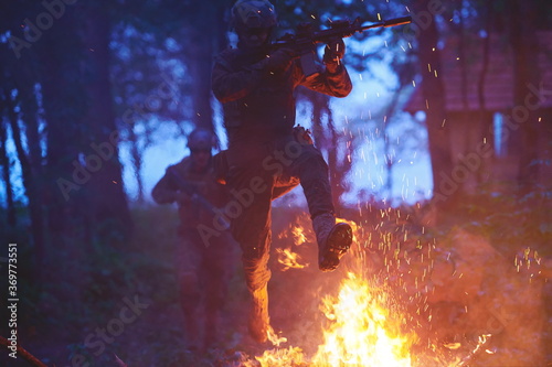 Soldier in Action at Night jumping over fire