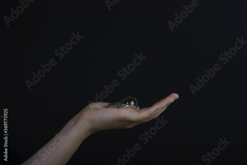 Hand holding lamp on dark background 