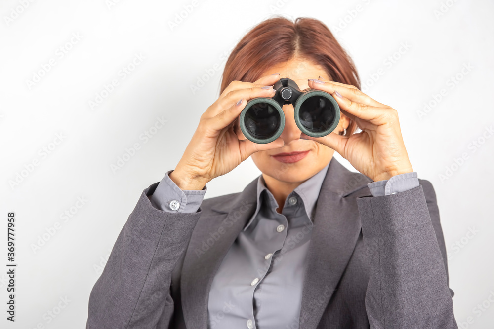 Business woman in suit looking through binoculars Business woman in suit looking through binoculars