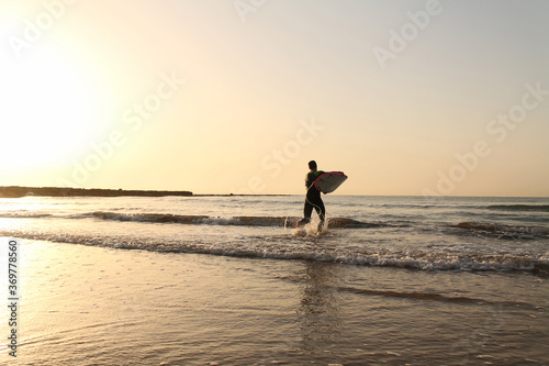 surfer runs through the waves