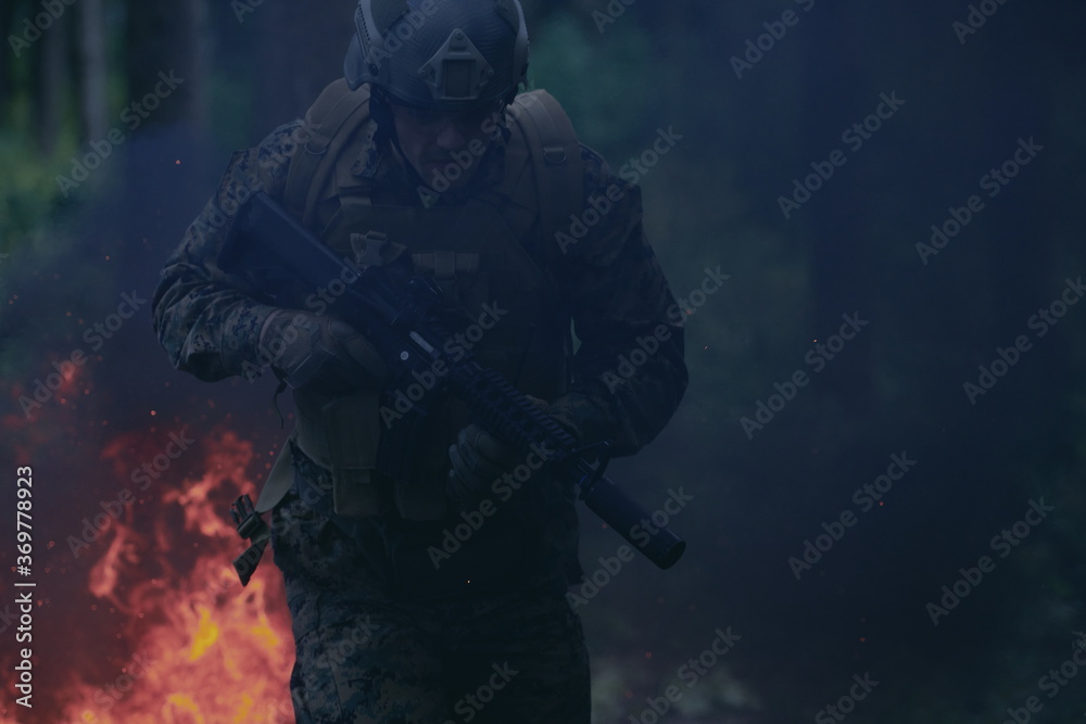 Soldier in Action at Night jumping over fire