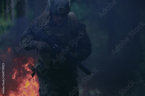 Soldier in Action at Night jumping over fire