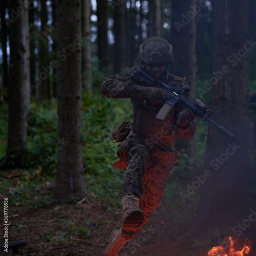 Soldier in Action at Night jumping over fire