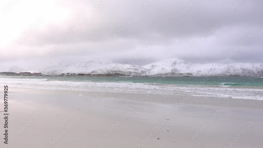 View of a snowy beach with mountains in the background in Lofoten, Norway