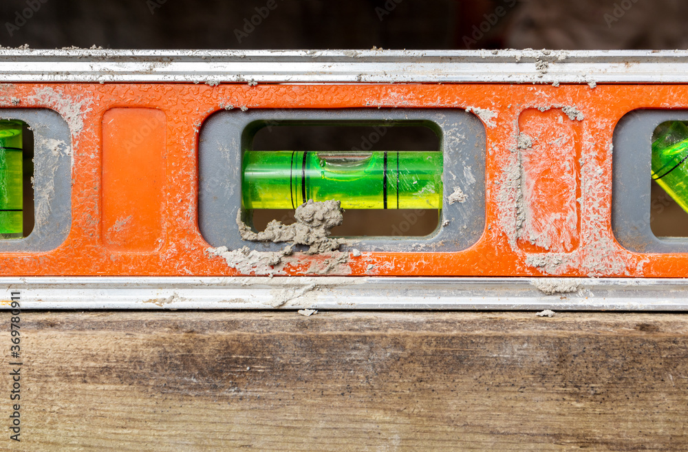 dirty-orange-tool-level-in-use-closeup-also-know-as-tubular-spirit