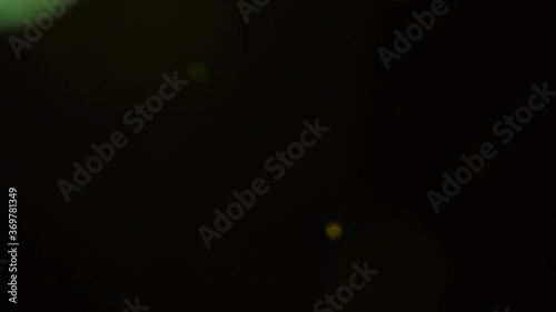 Lens flares in green glow on black background photo