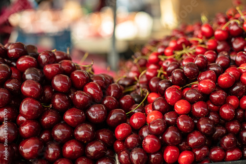 Closeup stock photo of heaps of fresh ripe sweet cherries for sale at the local wholesale market.
