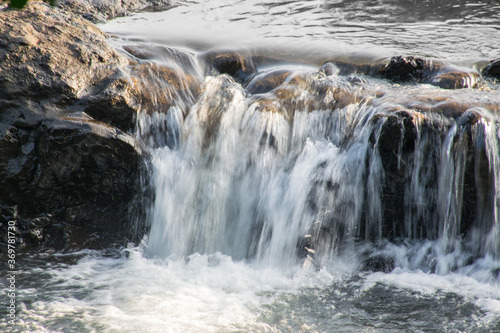 Panoramic view of a small waterfall with rocks located in rural India