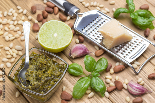 Basil leaves, olive oil, parmesan on grater, garlic, pine nuts. Pesto sauce cooking