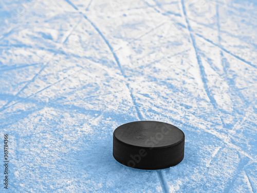 Puck on blue ice hockey rink surface