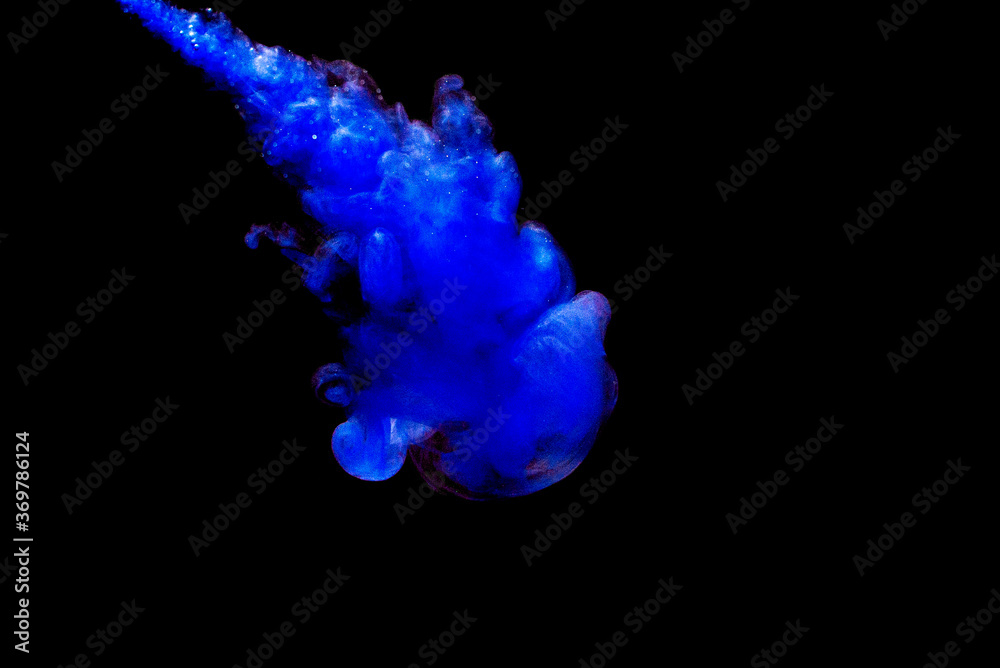 A cloud of blue paint released into clear water. Isolate on a black background.