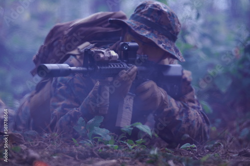 soldier in action aiming  on weapon  laser sight optics