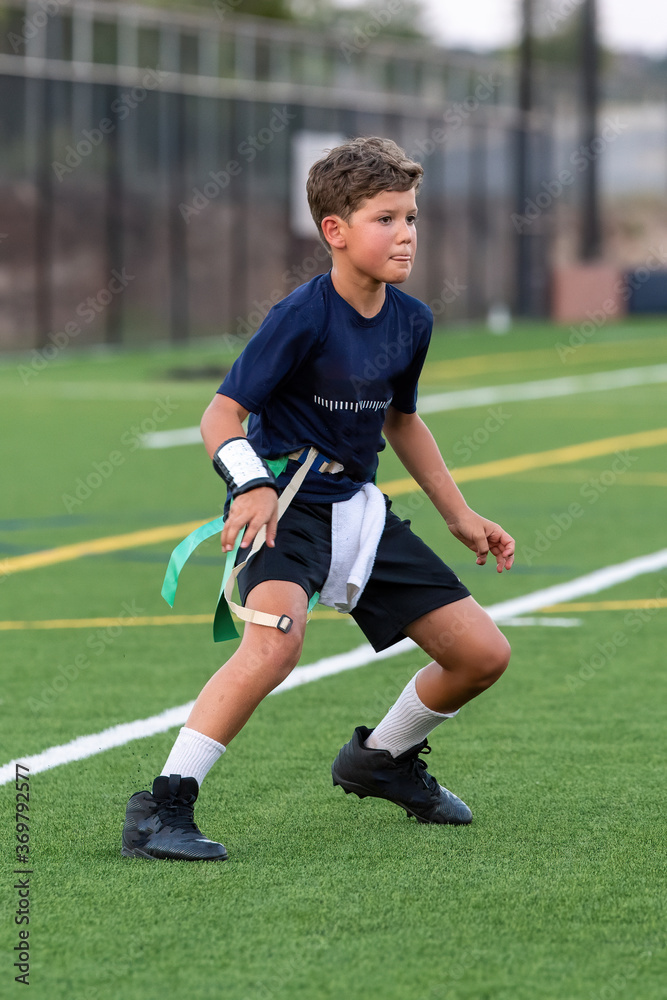 Obraz premium Young athletic boy playing in a flag football game