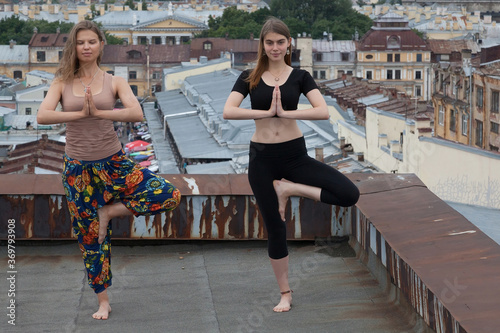 Young girls doing yoga on the rooftop in the old city