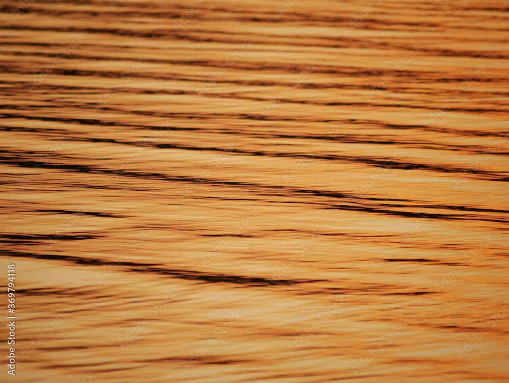wavy surface of water with gold sunset colour wavy surface of water with gold sunset colour