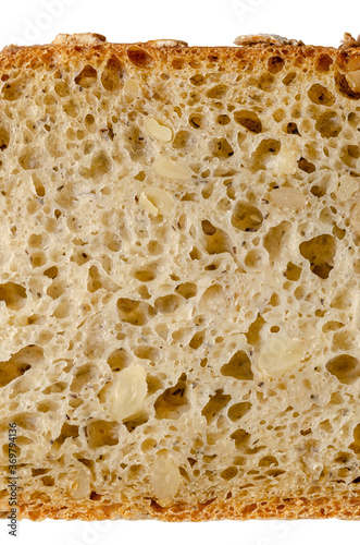 Slice of spelt bread, from above, close-up. Brown sourdough bread, mix of spelt flour, leaven, sunflower seeds and spices, baked in oven. Staple food. Isolated, on white background, macro food photo.