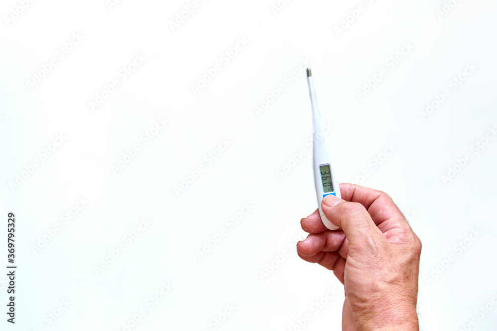Old man's hands holding digital thermometer to measure body temperature. Means of coronavirus prevention and treatment. Covid-19. Health concept. Old man's hands holding digital thermometer to measure body temperature. Means of coronavirus prevention and treatment. Covid-19. Health concept.