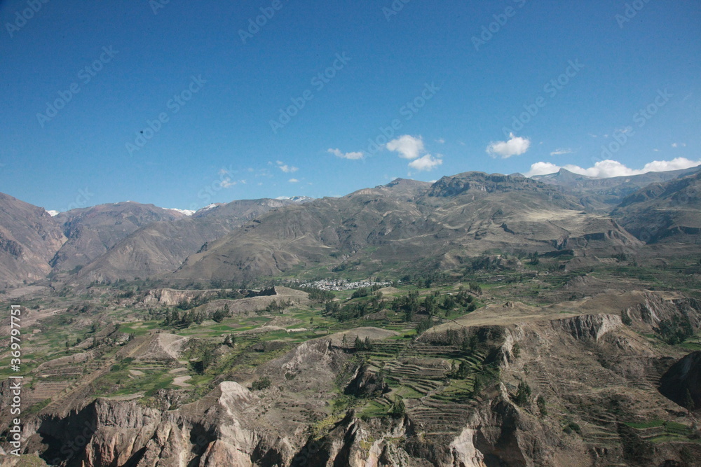 A small village in a mountainous landscape with many agricultural parts