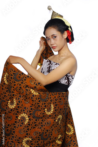 Beautiful Young Woman covering his body with Jarik. a woman using traditional javanese lurik batik and bun on hair. photo