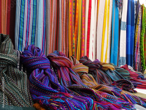Many scarfs put next to eachother in all colores at an andean market of South America photo