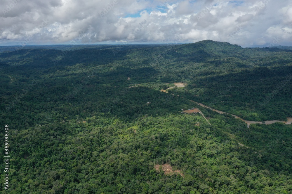 Aerial view of the a small community in the rainforest that is located next to a large river