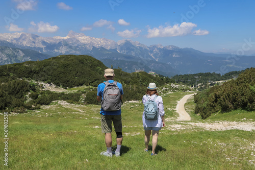 Couple walking with view to the mountain Triglav in Vogel Ski Resort, Slovenia in summer