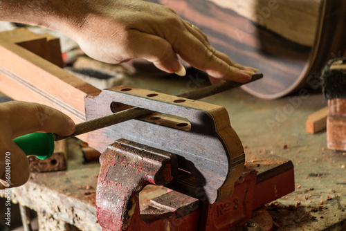 Luthier making a peghead of classical guitar