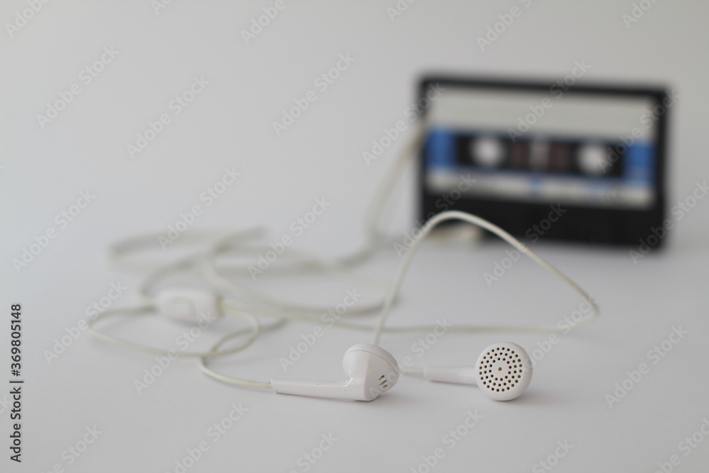 Blue -White audio cassette and cassette pleer with headphones on a white background. Party 90s concept Blue -White audio cassette and cassette pleer with headphones on a white background. Party 90s concept